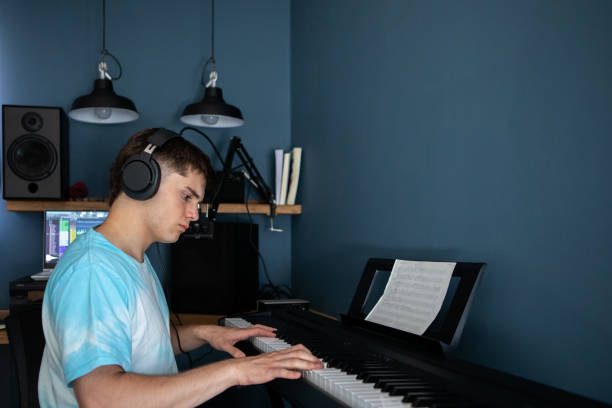 istock Young man producing music in his home recording music studio 2184490495