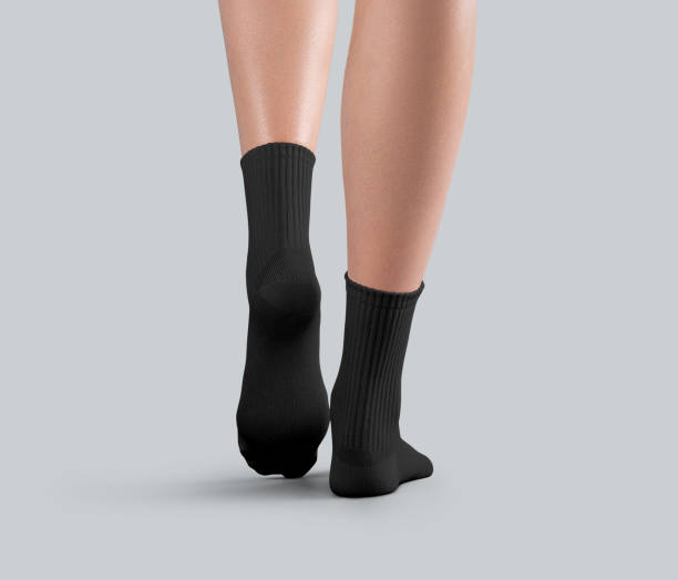 istock Template of black medium gaiters on thin female legs, back view, one ankle stretched, isolated on background. 2184492764