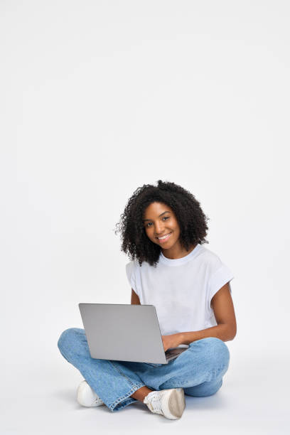 istock Happy young African woman student sitting isolated at white using laptop. 2184496991
