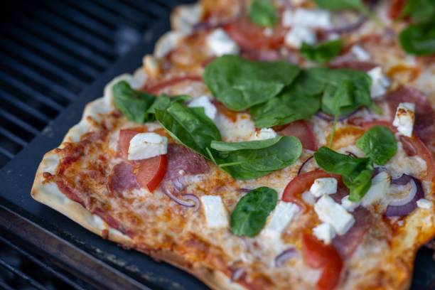 istock Gourmet pizza with fresh toppings on a grill. 2184503621