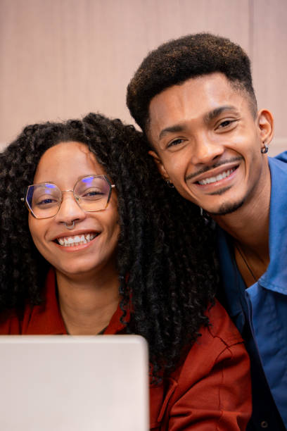 istock Smiling Friends Working Together on Laptop in a Cozy Setting.Vertical 2184504398