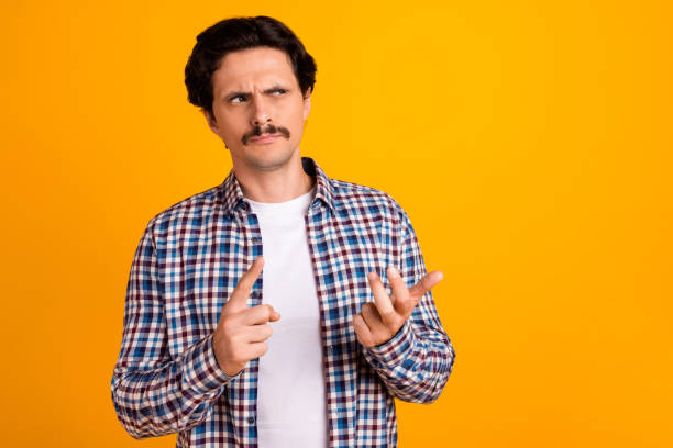istock Photo of handsome unsure young guy fingers count math problem look empty space wear trendy plaid look isolated on yellow color background 2184506483