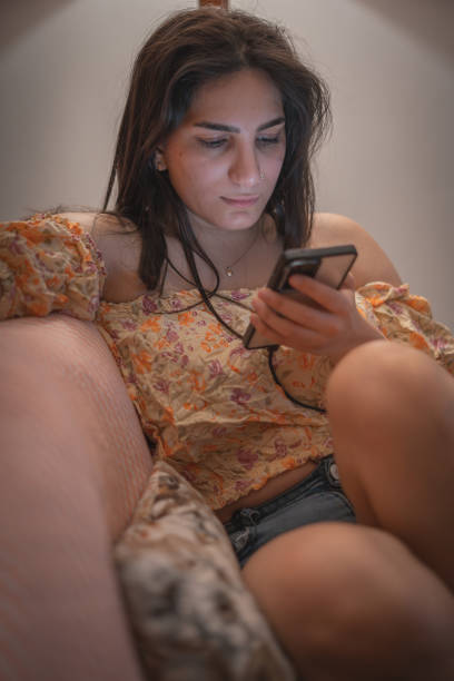 istock Relaxed Woman Browsing Phone at Home 2184510376