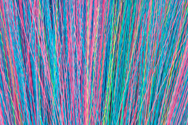 istock Colorful Wavy Threads Creating a Vibrant Background of Intertwined Textures in Bright Shades of Blue, Pink, Green, and Yellow for Creative Projects and Artistic Designs 2184514045