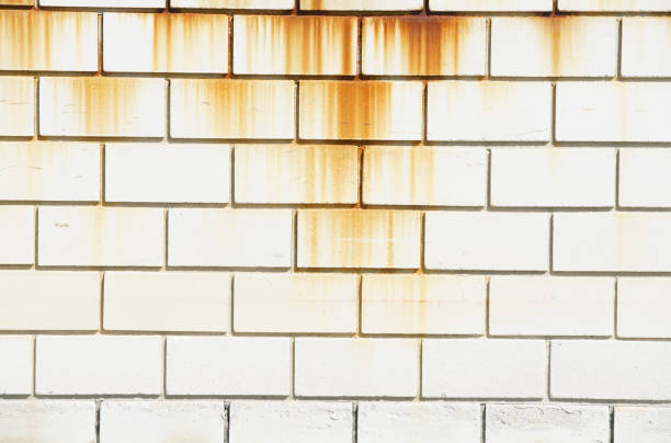 Captivating image of a cement wall displaying rust stains and weathered texture, perfect for creative projects that require an industrial or vintage aesthetic.