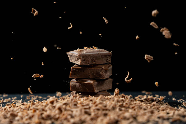 istock Grated chocolate sprinkle on milk chocolate pieces on black background 2184516086