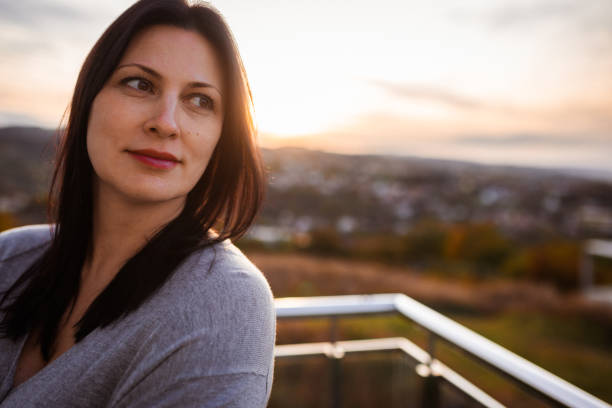Contemplative Woman Enjoying Serene Sunset in Countryside Setting