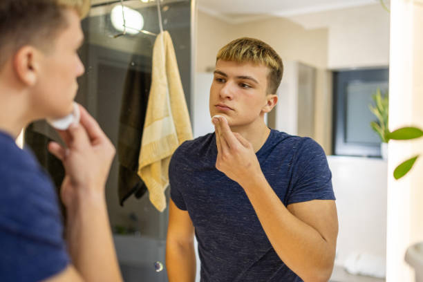 istock Young Man Practicing Daily Grooming Routine in the Bathroom Mirror 2184518063
