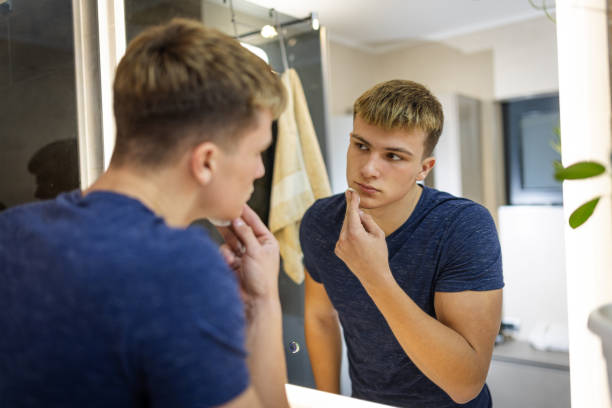 istock Young Man Practicing Daily Grooming Routine in the Bathroom Mirror 2184518073