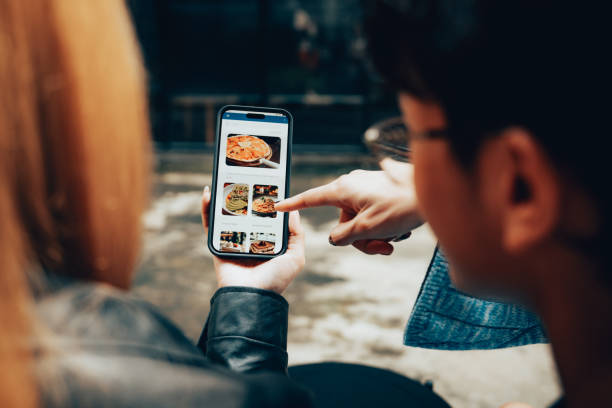 Friends Using Mobile Food Delivery App to Browse Menu and Order Online