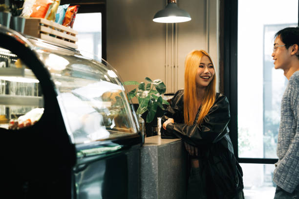 Young adults smiling and making food choices at a stylish cafe. Captures the essence of friendship, casual dining, and the warmth of shared moments in an inviting environment.