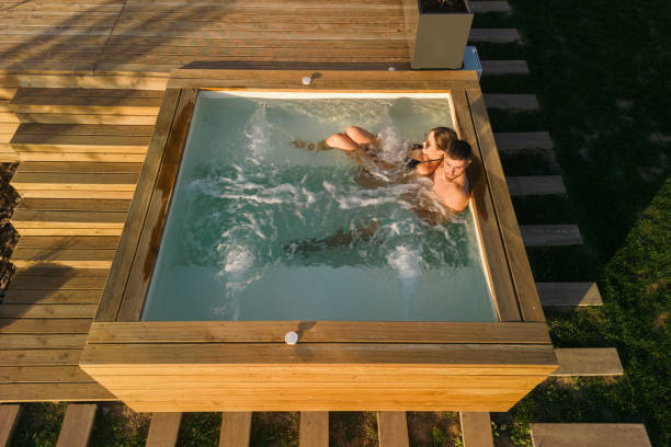 Couple having a relaxing time in hot tub on a patio on a beautiful summer day.