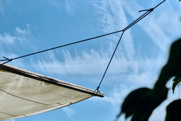istock White canopy against a blue sky shows intricate rope structure on a sunny day 2184518702