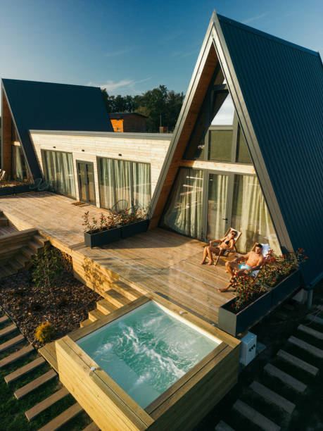 istock Couple sunbathing in front of an A-frame house 2184518739