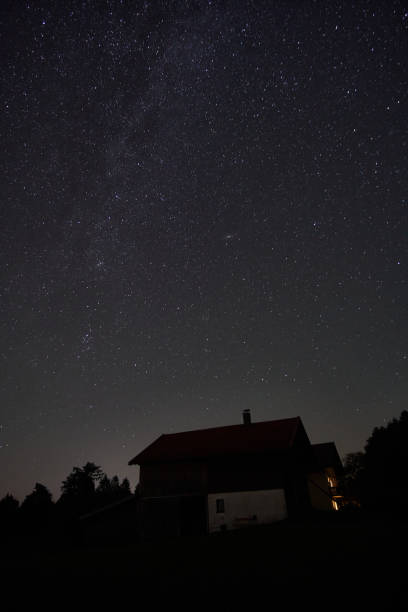 istock Starry night sky over a rustic house in a quiet rural area during late evening hours 2184519672
