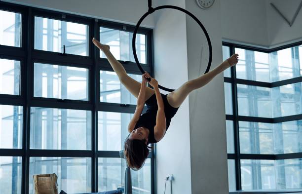 istock Aerial acrobat performing on a hoop in a modern studio. 2184520665