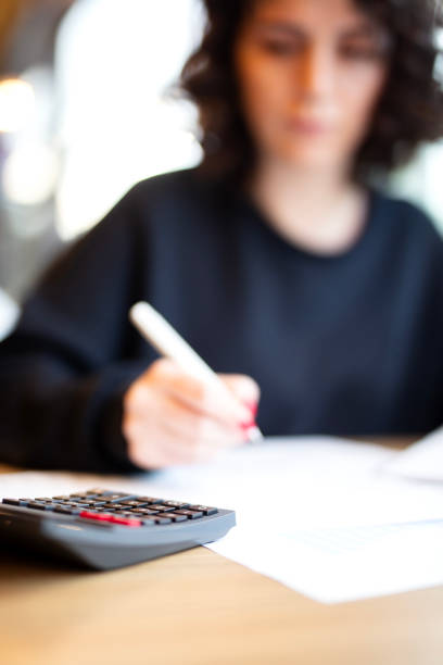 istock Woman at desk in office using calculator 2184521801