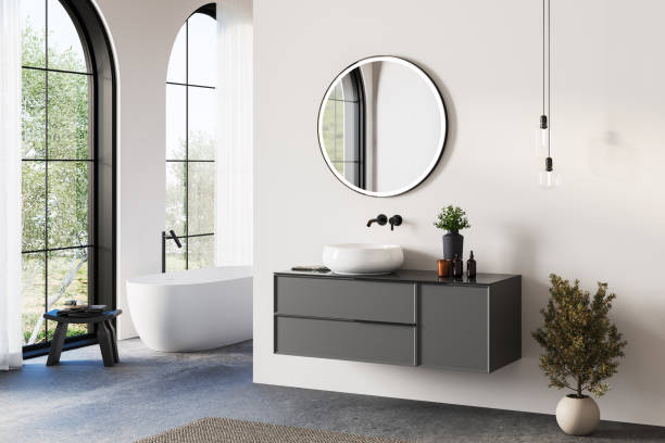 istock Modern bathroom interior with white bathtub and chic vanity, white walls, concrete floor, arches, yard 2184523780
