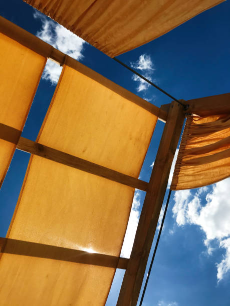 istock Looking upward through fabric canopy under a bright blue sky 2184525214