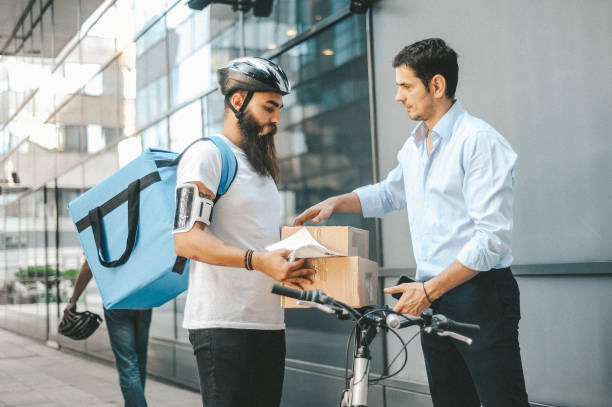 istock Delivery Man Handing Package to Businessman 2184530162