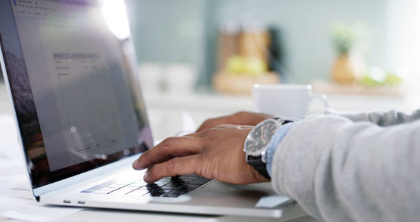 istock Man, hands or laptop screen in home for remote work, planning or connectivity for banking. Person, typing or computer in kitchen for budget, finance management or entrepreneur on tech for networking 2184536269