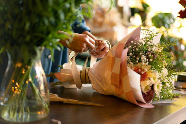Woman's hand preparing bouquet in flower shop