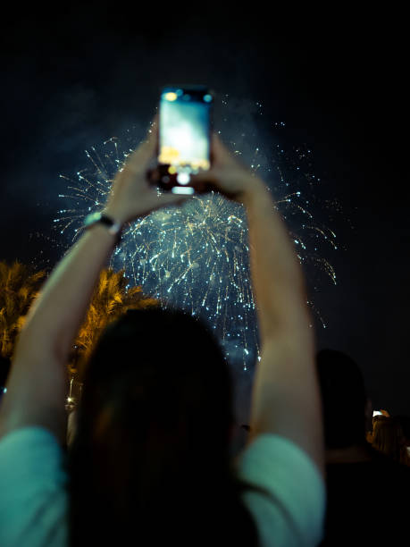 istock Person enjoying fireworks display while taking a photo at night 2184536572