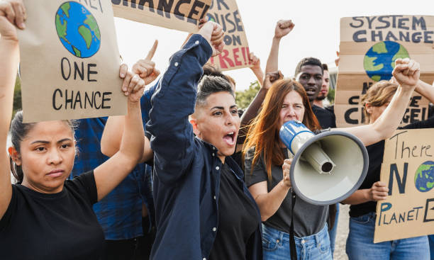 istock Multigenerational people protest against climate change - Crowd doing demonstration for stopping pollution - Green and environment concept - Focus on woman with short hair 2184538063