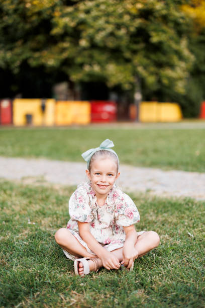istock Girl sitting on grass in school garden 2184541054