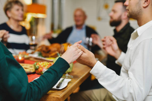 istock Family Bonding While Sitting on Dining Table Holding Hands and Praying 2184544883