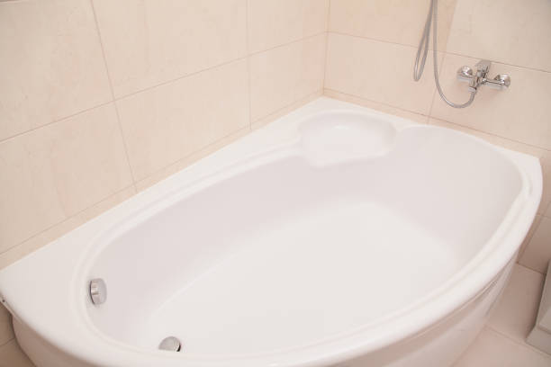 Minimalist white bathroom interior with bathtub, sink, and radiator. Modern home renovation and sanitary ware concept.