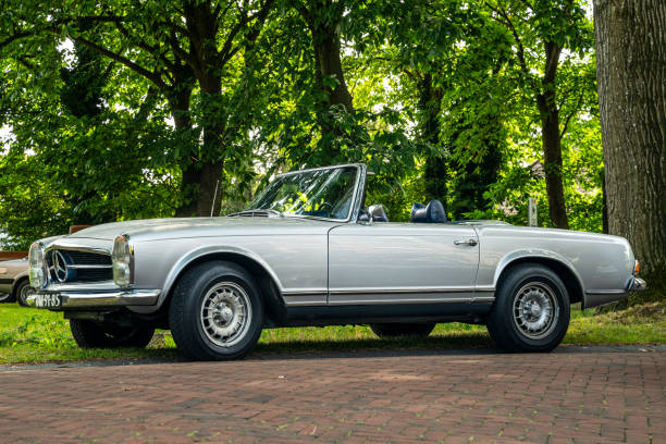 Mercedes-Benz 280SL Pagode classic German convertible car parked on the side of the road. The car is on display during the annual Oldtimer day in Ruinerwold.