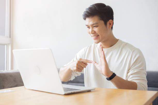 istock close up young asian man make gesture hand about sign language to teaching or talking to colleague on video conference program in office meeting room for business lifestyle concept 2184547718