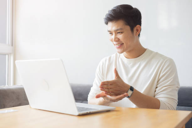 istock close up young asian man make gesture hand about sign language to teaching or talking to colleague on video conference program in office meeting room for business lifestyle concept 2184547731