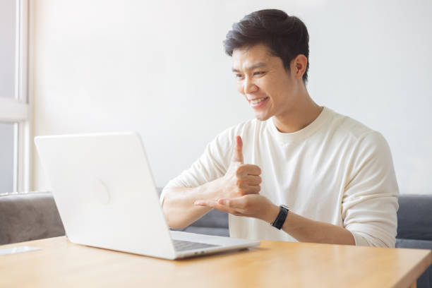 istock close up young asian man make gesture hand about sign language to teaching or talking to colleague on video conference program in office meeting room for business lifestyle concept 2184547734