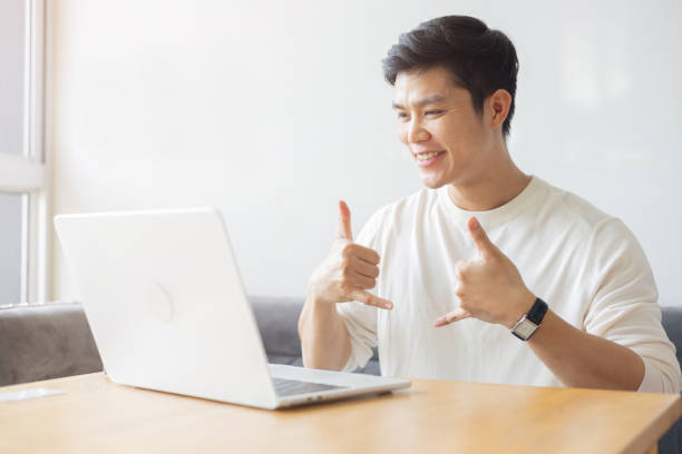 istock close up young asian man make gesture hand about sign language to teaching or talking to colleague on video conference program in office meeting room for business lifestyle concept 2184547738