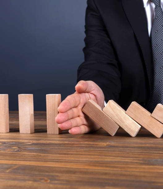 Businessman hand stop domino effect