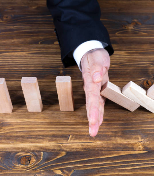 istock Businessman hand stop domino effect 2184548905