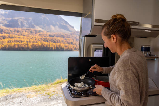 istock Young woman prepares foo in her van by the lake 2184553769