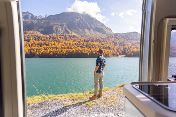 istock Young Man Enjoying Lake and Mountain View from Camper Van 2184554033