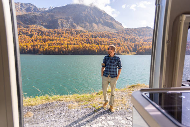 istock Man Enjoying Lake and Mountain View from Camper Van 2184554040