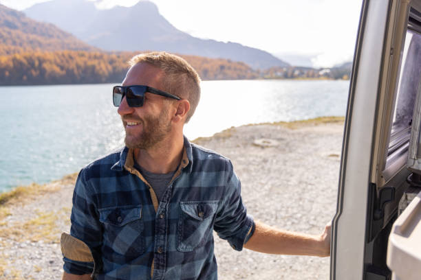 istock Smiling Man Enjoying Lake View from Camper Van 2184554080