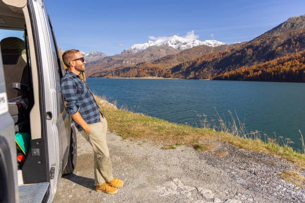 istock Man Relaxing by Camper Van with Stunning Lake and Mountain View 2184554090
