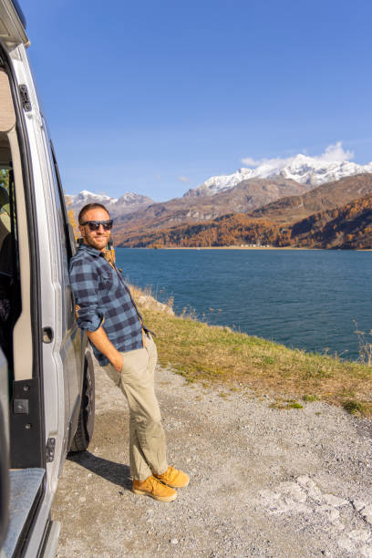 istock Man Relaxing by Camper Van with Stunning Lake and Mountain View 2184554093