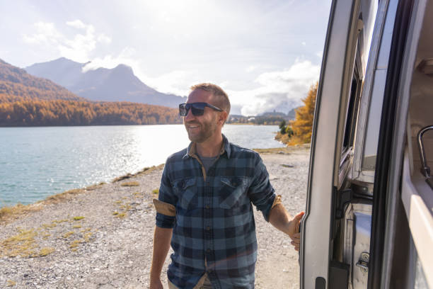 istock Man Enjoying Scenic Lake and Mountain View from Camper Van 2184554408