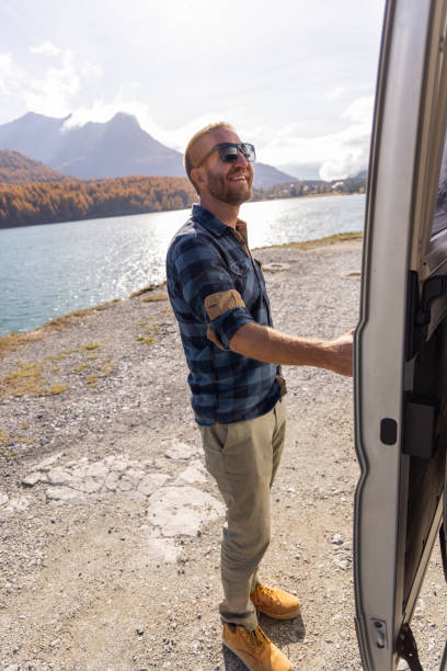 istock Man Enjoying Scenic Lake and Mountain View from Camper Van 2184554570