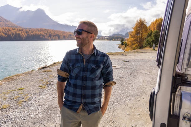 istock Man Smiling by a Lake on a Bright Autumn Day 2184554575