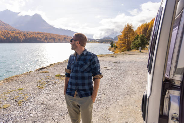 istock Man Smiling by a Lake on a Bright Autumn Day 2184554816
