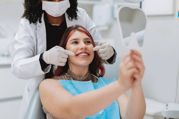 istock Woman undergoing dental treatment holding mirror 2184556520