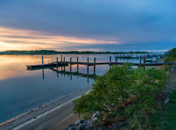 Landscape of the Caorle lagoon in Italy, with wooden pier, illuminated by the first warm lights of dawn